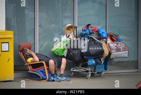 Obdachlosen mit vielen Taschen auf Gepäck Trolley, schläft auf dem Bürgersteig, Köln, Nordrhein-Westfalen, Deutschland Stockfoto