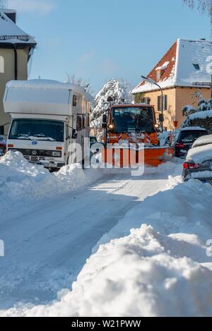 Schneepflug fährt durch enge Strasse mit Schnee geparkten Autos, München, Oberbayern, Bayern, Deutschland Stockfoto