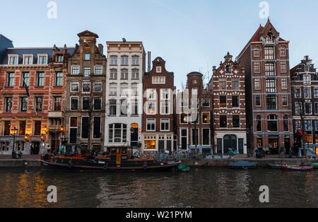 Historische Häuserzeile an einem Kanal in der Dämmerung, Amsterdam, Nordholland, Niederlande Stockfoto