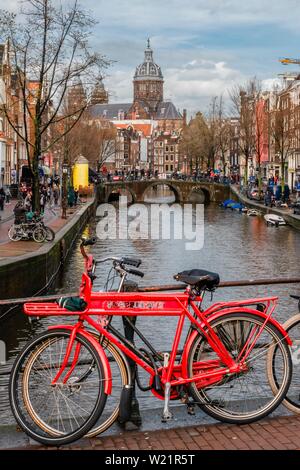 Parkplatz Fahrräder, Blick von einer Brücke an Oudezijds Voorburgwal zum Kanal und die Sint Nicolaaskerk, Sankt Nikolaus-Kirche, Amsterdam, Nordholland Stockfoto