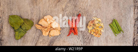 Zutaten für populäre thailändische Suppe Tom - Yum Kung. Kalk, Galgant, roter Chili, Cherry Tomaten, Zitronengras und Kaffernlimette Blatt auf dem Schwarzen Brett. Flach Stockfoto