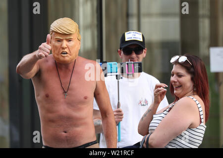 Unterstützer von Tommy Robinson, eine trägt ein Donald Trump Maske, für seine Ankunft im Old Bailey in London, wo er aufgrund einer Anklageerhebung wegen angeblicher Missachtung des Gerichts zu warten. Stockfoto