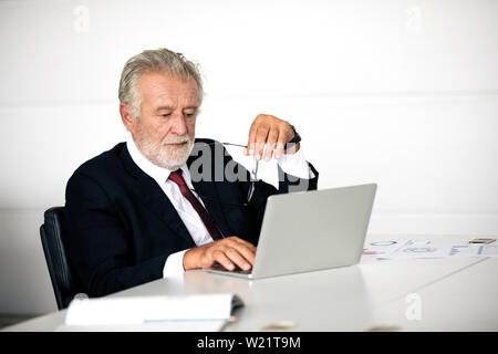 Unternehmer mit Notebook und füllen Sie ernsthaft an die Arbeit, bis die Kopfschmerzen getan Stockfoto