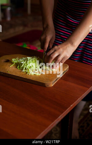 Hausfrau einen Salat aus frischem gesunden Gemüse. Junge Frau, Salat in der Küche Stockfoto