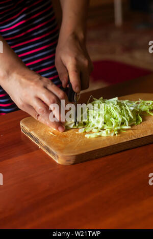 Hausfrau einen Salat aus frischem gesunden Gemüse. Junge Frau, Salat in der Küche Stockfoto