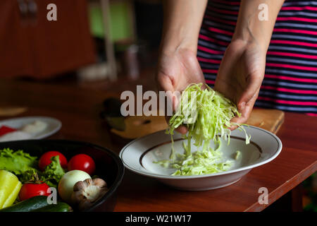 Hausfrau einen Salat aus frischem gesunden Gemüse. Junge Frau, Salat in der Küche Stockfoto