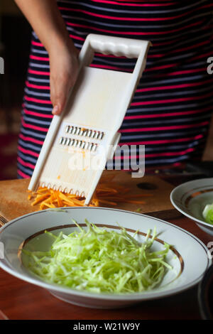 Hausfrau einen Salat aus frischem gesunden Gemüse. Junge Frau, Salat in der Küche Stockfoto