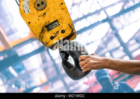 Industrielle Kranhaken geführte durch Ingenieure Hand Stockfoto