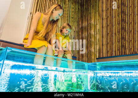 Mutter und Sohn am Fish Spa BANNER, LANGE FORMAT Stockfoto