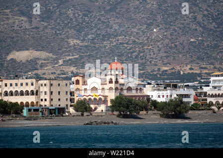 Ierapetra, Kreta, Griechenland. Juni 2019. Die südlichen Küsten Stadt Ierapetra und die Kirche von Agia Fotini mit einer Bergkulisse Stockfoto