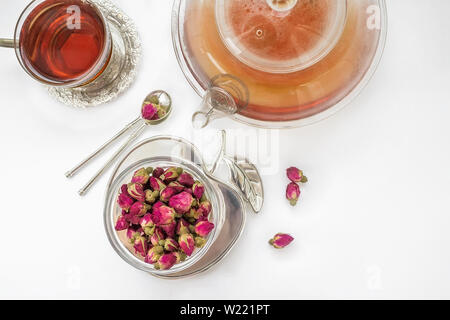 Tee aus rosenblütenblätter. Tea Rose Knospen von real Rosenknospen, gezupften Junge und dann getrocknet. Eine Tasse Tee und eine transparente Teekanne mit einem schönen Stockfoto