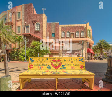 Netten Straße Kunst Malerei auf einer Bank in der Okinawa Markt shop Mall der amerikanischen Dorf Chatan Stadt, wo die Verzerrung am Meer, Eiche Art und Weise und D Stockfoto