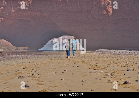 Ein Mann und eine Frau am Strand entlang in der Nähe von Legzira in Marokko. Romantische Liebe in der Nähe von Legzira Bech Stockfoto