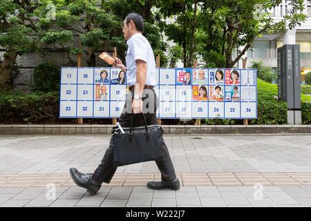 Tokio, Japan. 05 Juni, 2019. Ein Mann der Vergangenheit eine Plakatwand mit Postern Kandidaten für den 21. Juli Bundesrat Wahl errichtet. Die Kampagnen für das obere Haus Wahl offiziell weg am Donnerstag, 04. Juli und am 21. Juli statt. Credit: Rodrigo Reyes Marin/LBA/Alamy leben Nachrichten Stockfoto