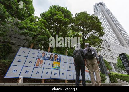 Tokio, Japan. 05 Juni, 2019. Leute schauen auf eine Plakatwand mit Postern Kandidaten für den 21. Juli Bundesrat Wahl errichtet. Die Kampagnen für das obere Haus Wahl offiziell weg am Donnerstag, 04. Juli und am 21. Juli statt. Credit: Rodrigo Reyes Marin/LBA/Alamy leben Nachrichten Stockfoto