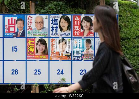 Tokio, Japan. 05. Juli, 2019. Eine Frau geht vorbei an einer Plakatwand mit Postern Kandidaten für den 21. Juli Bundesrat Wahl errichtet. Die Kampagnen für das obere Haus Wahl offiziell weg am Donnerstag, 04. Juli und am 21. Juli statt. Credit: Rodrigo Reyes Marin/LBA/Alamy leben Nachrichten Stockfoto