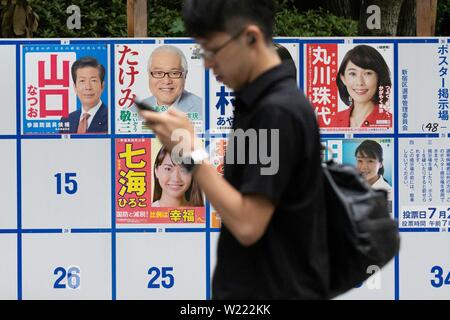 Tokio, Japan. 05. Juli, 2019. Ein Mann der Vergangenheit eine Plakatwand mit Postern Kandidaten für den 21. Juli Bundesrat Wahl errichtet. Die Kampagnen für das obere Haus Wahl offiziell weg am Donnerstag, 04. Juli und am 21. Juli statt. Credit: Rodrigo Reyes Marin/LBA/Alamy leben Nachrichten Stockfoto