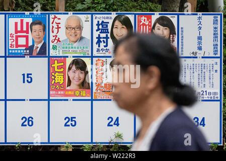 Tokio, Japan. 05. Juli, 2019. Eine Frau geht vorbei an einer Plakatwand mit Postern Kandidaten für den 21. Juli Bundesrat Wahl errichtet. Die Kampagnen für das obere Haus Wahl offiziell weg am Donnerstag, 04. Juli und am 21. Juli statt. Credit: Rodrigo Reyes Marin/LBA/Alamy leben Nachrichten Stockfoto