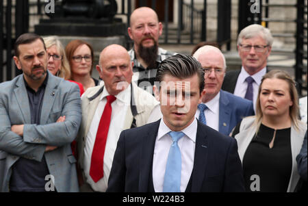 Anwalt Darragh Mackin, zusammen mit betroffenen Familien und Unterstützer, spricht mit den Medien außerhalb des Belfaster Gericht Beschwerde ein Urteil in einem Fall, in dem es um die polizeiliche Untersuchung der loyalistischen Gleanne Bande. Stockfoto