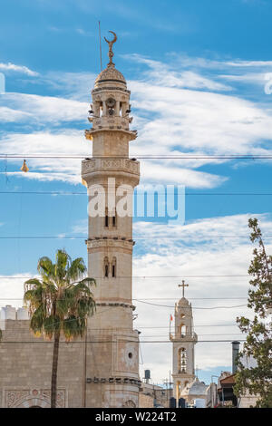 Muslimisches Minarett und christliche Kirche im Hintergrund in Bethlehem, Palästina. Stockfoto