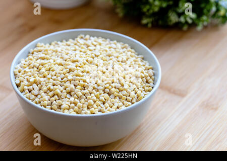 Raw trocken Bio Couscous in eine Schüssel geben. Türkische Kuskus Stockfoto
