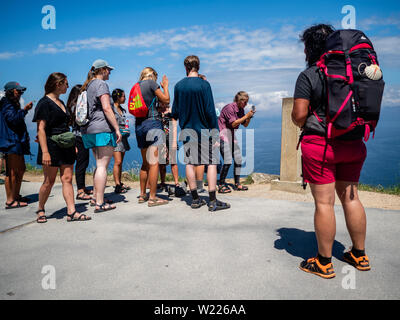 Eine Gruppe von Pilgern zu sehen sind die Fotos in der KM0-Marker. Kap Finisterre ist das Ziel für die Pilger, die nach dem Besuch der St James' Grab ist Santiago, ihren Weg weiter entlang der Route, die für Sie gekennzeichnet durch die Milchstraße Overhead, bis Sie nicht mehr weiter konnten. Finisterre war während der Zeit der klassischen Antike das Ende der bekannten Welt. Finisterre, oder Fisterra in Gallego, der lokalen Galizischen Dialekt bedeutet "Land's End" in Lateinamerika. Weiter zum Leuchtturm, gibt es die 0.0 Kilometer Marker von wo der Atlantische Ozean es gesehen werden kann. Dieser Ort ist auch Stockfoto