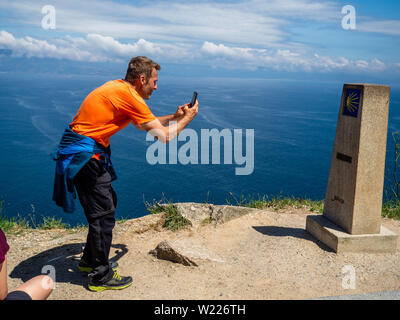 Juni 27, 2019 - Finisterra, A CoruÃ±a, Spanien - ein pilger gesehen ist ein Foto von der km0-Marker. Kap Finisterre ist das Ziel für die Pilger, die nach dem Besuch der St. James €™ Grab ist Santiago, ihren Weg weiter entlang der Route, die für Sie gekennzeichnet durch die Milchstraße Overhead, bis Sie nicht mehr weiter konnten. Finisterre war während der Zeit der klassischen Antike das Ende der bekannten Welt. Finisterre, oder Fisterra in Gallego, der lokalen Galizischen Dialekt bedeutet ''Land's End'' in Lateinamerika. Weiter zum Leuchtturm, gibt es die 0.0 Kilometer Marker von wo der Atlantische Stockfoto