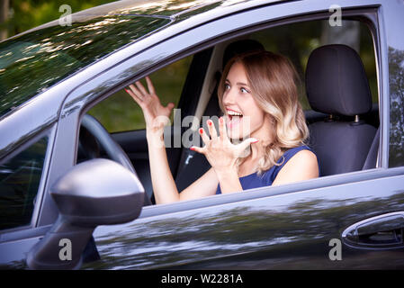 Junge Angst Frau in Schwarz auto. Stockfoto