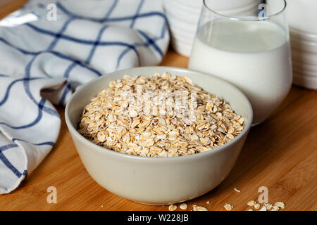 Schüssel Haferflocken und Glas Milch Stockfoto