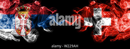 Serbien vs Schweiz, Schweizer smoky mystic Flaggen nebeneinander. Dicke farbige seidig raucht Kombination der Serbischen und der Schweiz, Schweizer Flagge Stockfoto