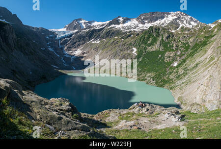 Wanderer oberhalb Triftsee mit Triftgletscher und mäanderndem Fluss in den Schweizer Alpen bei Gadmen Stockfoto