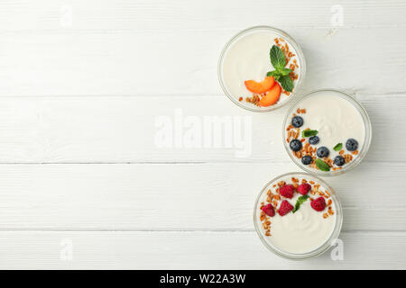 Flach Zusammensetzung mit Joghurt und Desserts Zutaten auf weißem Holz- Hintergrund Stockfoto