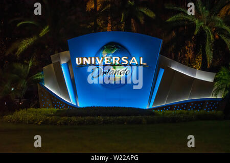 Orlando, Florida. Juni 13, 2019. Leuchten Universal Orlando Logo auf Palmen im Hintergrund auf dem Universal Boulevard. Stockfoto