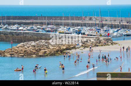 Lyme Regis, Dorset, Großbritannien. 4. Juli 2019. UK Wetter: Sonnenanbeter in Scharen zu den Strand im Badeort von Lyme Regis bis glühend heiße Sonne und blauen Himmel vor dem Wochenende zu genießen. Credit: Celia McMahon/Alamy Leben Nachrichten. Stockfoto