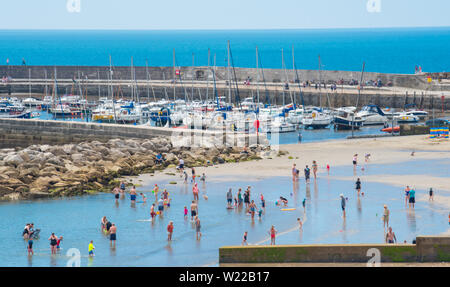 Lyme Regis, Dorset, Großbritannien. 4. Juli 2019. UK Wetter: Sonnenanbeter in Scharen zu den Strand im Badeort von Lyme Regis bis glühend heiße Sonne und blauen Himmel vor dem Wochenende zu genießen. Credit: Celia McMahon/Alamy Leben Nachrichten. Stockfoto