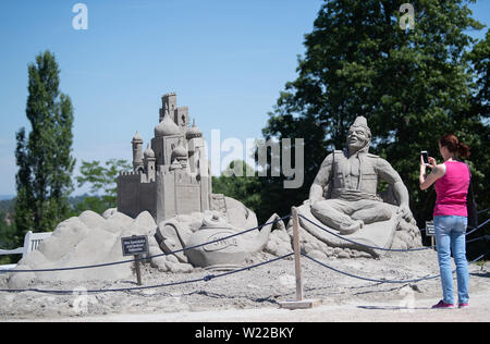 Ludwigsburg, Deutschland. 05. Juli, 2019. Ein Besucher der'S und Kunst" Ausstellung in der Gartenschau "Blühendes Barock" Fotografien eine Sand Skulptur, basierend auf dem Märchen Aladin. Sand-Kunst 2019' zeigt sand Figuren von verschiedenen Künstlern von 06. Juli bis 29. August. Credit: Marijan Murat/dpa/Alamy leben Nachrichten Stockfoto