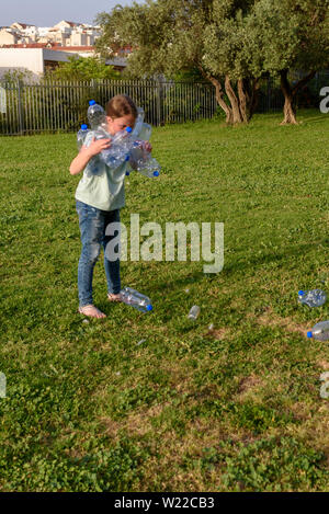 Junge Jugendmädchen recycling Plastikflaschen. Kid freiwillige Reinigung Park im Freien. Stockfoto