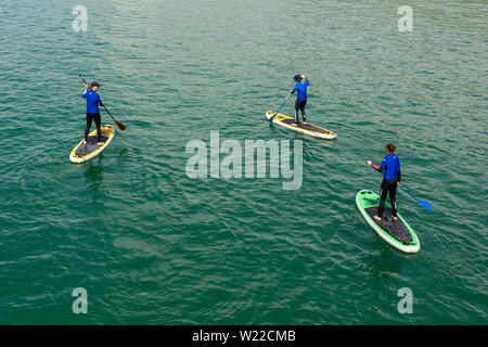 Paddleboarders, Boscombe, Bournemouth, Dorset, England, Großbritannien, 5. Juli 2019, Wetter: Die Temperaturen steigen am Freitagmorgen, was dies zum wärmsten Tag im Juli macht, an dem es eine kurze Hitzewelle geben wird. Paddelboarder sind früh unterwegs, um die ruhigen Meeresbedingungen zu genießen. Stockfoto