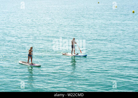 Paddleboarders, Boscombe, Bournemouth, Dorset, England, Großbritannien, 5. Juli 2019, Wetter: Die Temperaturen steigen am Freitagmorgen, was dies zum wärmsten Tag im Juli macht, an dem es eine kurze Hitzewelle geben wird. Paddelboarder sind früh unterwegs, um die ruhigen Meeresbedingungen zu genießen. Stockfoto