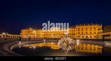 Schloss Schönbrunn in Wien, Österreich, in der Nacht. Schöne Nacht Szene mit dunkelblauen Himmel und Brunnen, Palast und Lichter in den Vordergrund. Stockfoto