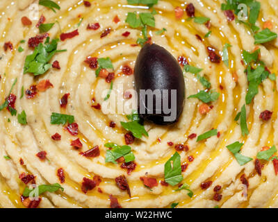 Hummus garniert mit Olivenöl, Pfeffer und gehackter Petersilie. Oriental, Türkische Vorspeise oder Starter meze. Stockfoto