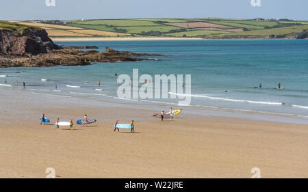 Surfer in Richtung Meer, am Strand von Polzeath in North Cornwall, UK. Am 27. Juni 2019 übernommen. Stockfoto