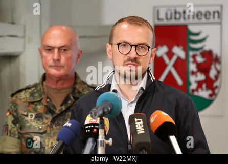 05 Juli 2019, Mecklenburg-Vorpommern, Lübtheen: Stefan Sternberg (SPD), Landrat des Landkreises Ludwigslust-Parchim, informiert vor der Stadt Wappen Lübtheen auf einer Pressekonferenz. Hinter ihm ist Brigadegeneral Gerd Kropf. Aufgrund der umfangreichen Waldbrand in der Nähe von Lübtheen, Hunderte Menschen mussten ihre Häuser verlassen. Foto: Bodo Marks/dpa Stockfoto