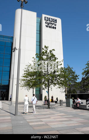 BBC Cymru Wales Ansicht von hinten zwei Personen tragen weiße Kleidung zu Fuß außerhalb des neuen Gebäudes in Central City Centre Cardiff Wales UK KATHY DEWITT Stockfoto