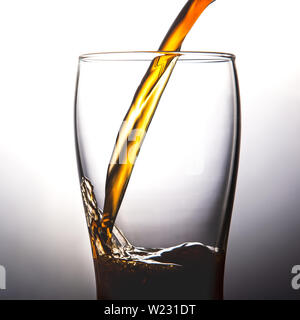Gießen Cola in Glas mit Eis auf weißem Hintergrund Kopie Raum Platz für Menü Text und dem Restaurant Konzept Stockfoto