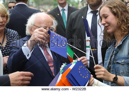 Würzburg, Deutschland. 05. Juli, 2019. Irische Präsident Michael D Higgins nimmt eine EU-Flagge von einem Bündel, die ihm von einem gut-wisher angeboten. Er hat Würzburg in Bayern besuchte heute auf der letzten Etappe seine diplomatischen Reise nach Deutschland. Anfang der Woche traf er, Angela Merkel, und der deutsche Präsident Frank Steinmeier. Präsident Higgins gestoppt an der Universität Bibliothek am Nachmittag Schätze der irischen Literatur und Kunst zu sehen, insbesondere die Arbeit des berühmten deutschen Philosophen, Sprachwissenschaftler und Lateinischen gelehrten Casper Zeuss, dessen Buch Grammatica Celtica zuerst die Grammatik der irischen Sprache dokumentiert. Stockfoto