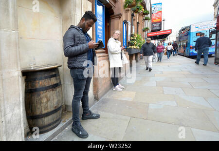 London, England, UK. Menschen auf ihren Handys in Whitehall Stockfoto