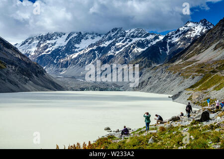 Wanderer kommen in Hooker See Am Ende der Hooker Valley Track, Aoraki/Mt Cook National Park, South Island, Neuseeland Stockfoto