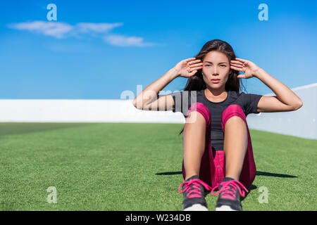 Sit-ups fitness Frau tun situps Ausbildung core abs Übungen außerhalb. Passform weiblichen Sport Modell Mädchen training crossfit im Freien auf Gras. Gemischte Rasse asiatischen Kaukasischen Athlet Knirschen zu tun. Stockfoto