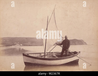 Viktorianische späten 1880er/frühen 1890Foto von einem Mann Stand In seinem Rudern/Fischerboot in Borth, Wales Stockfoto